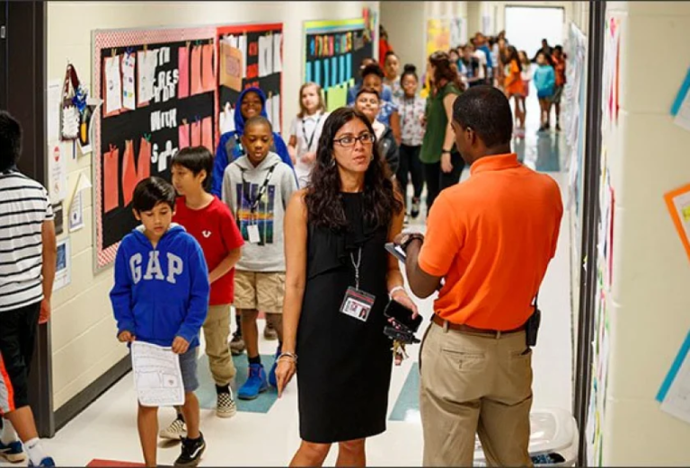 principal speaking to teacher in hallway