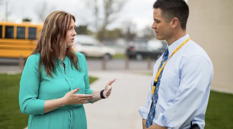School executive having in-person conversation with central office colleague instead of email communication
